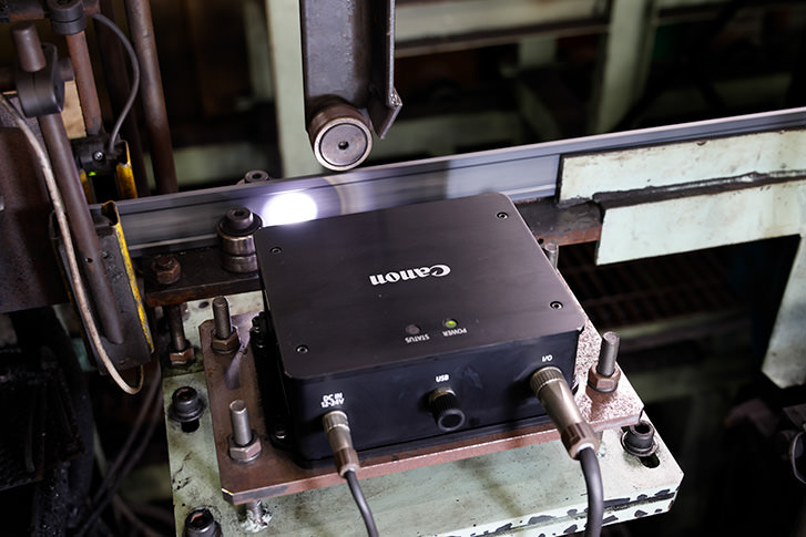 Canon's non-contact length measurement system measuring steel movement on a production line