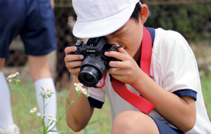 An elementary school student participating in a photography class